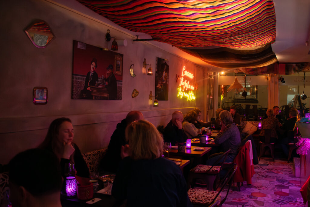 Gasten genieten van het verrassingsmenu van de chef in een sfeervol restaurant geïnspireerd op Zuid-Europa en Noord-Afrika.