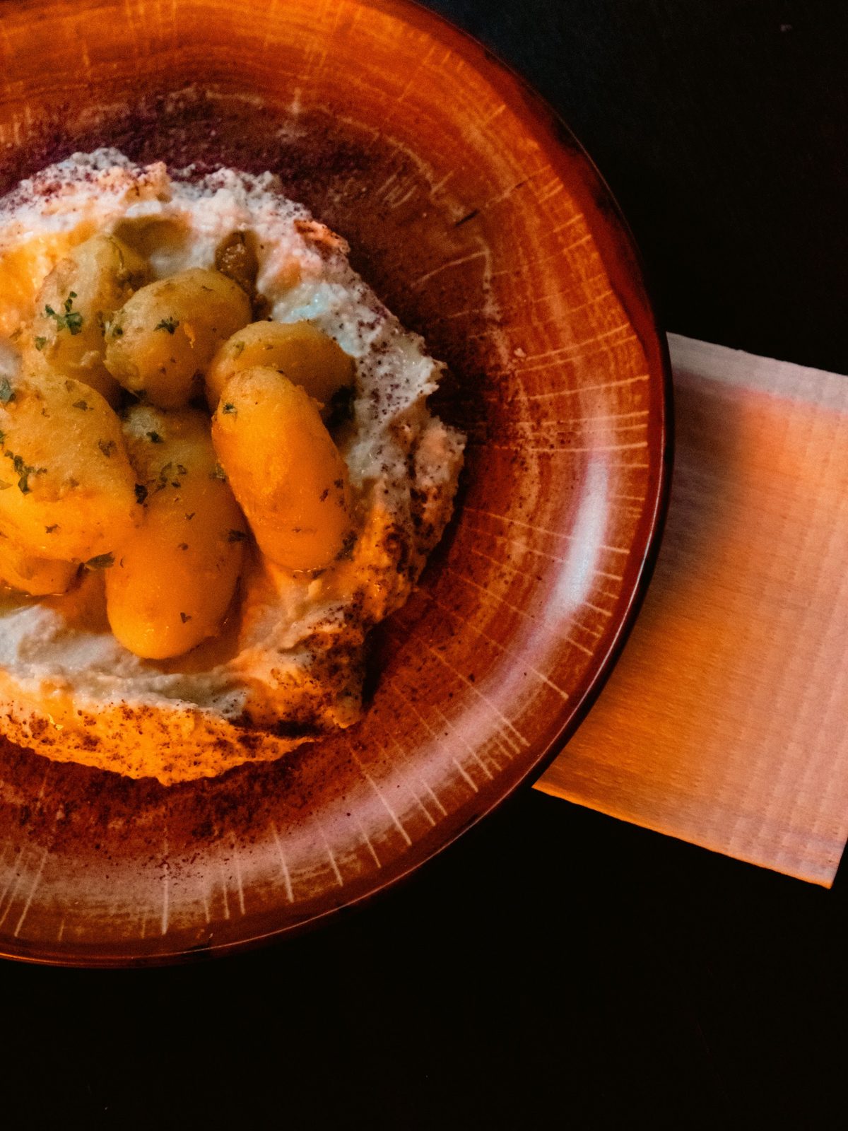 Marokkaanse couscous met seizoensgroenten in oranje aardewerk schaal bij LaSqala in Zwolle.