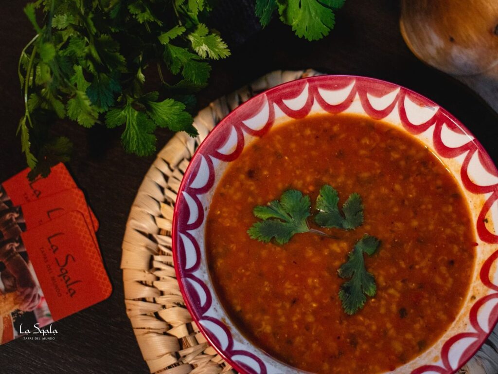 Marokkaanse harira soep met linzen en kikkererwten in een handbeschilderde kom bij LaSqala Zwolle.